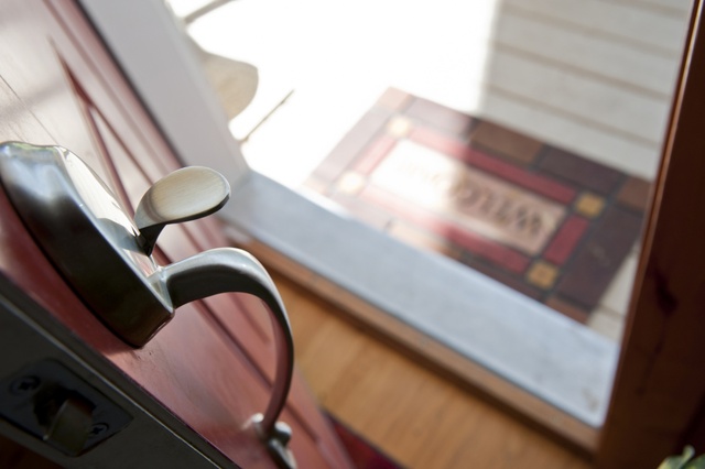 Door stands open with welcome mat visible outside