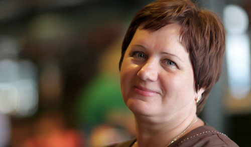 A woman with short reddish hair looks happily at the camera