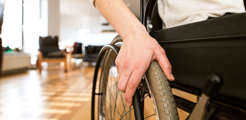 Hand and arm preparing to push wheelchair